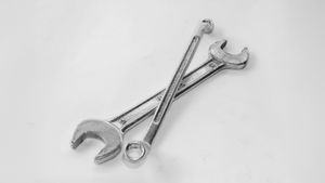 Two crossed wrenches on a white surface, symbolizing development tools and craftsmanship